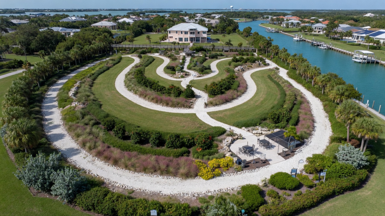 Stunning aerial view of a hurricane-resilient native landscape in Cape Coral with layered planting design, winding shell pathways, and strategic hardscaping, bright daylight, 8K resolution